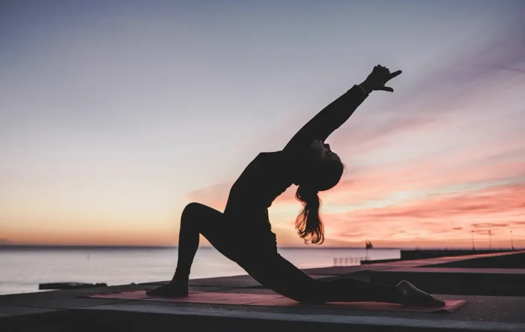 Person stretching at sunset